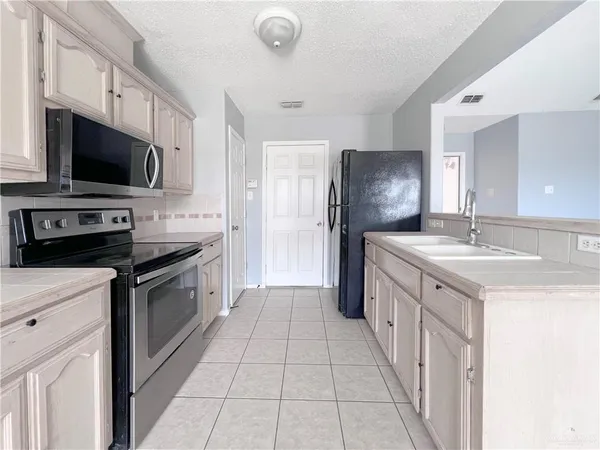 a kitchen with stainless steel appliances a stove sink microwave and refrigerator