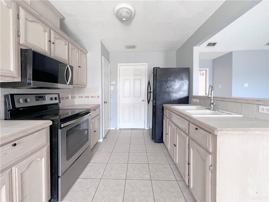 5716 North 38th Street McAllen, TX 78504 - Photo 7 of 28 a kitchen with stainless steel appliances a stove sink microwave and refrigerator