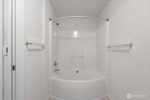 a white bath tub sitting next to a shower