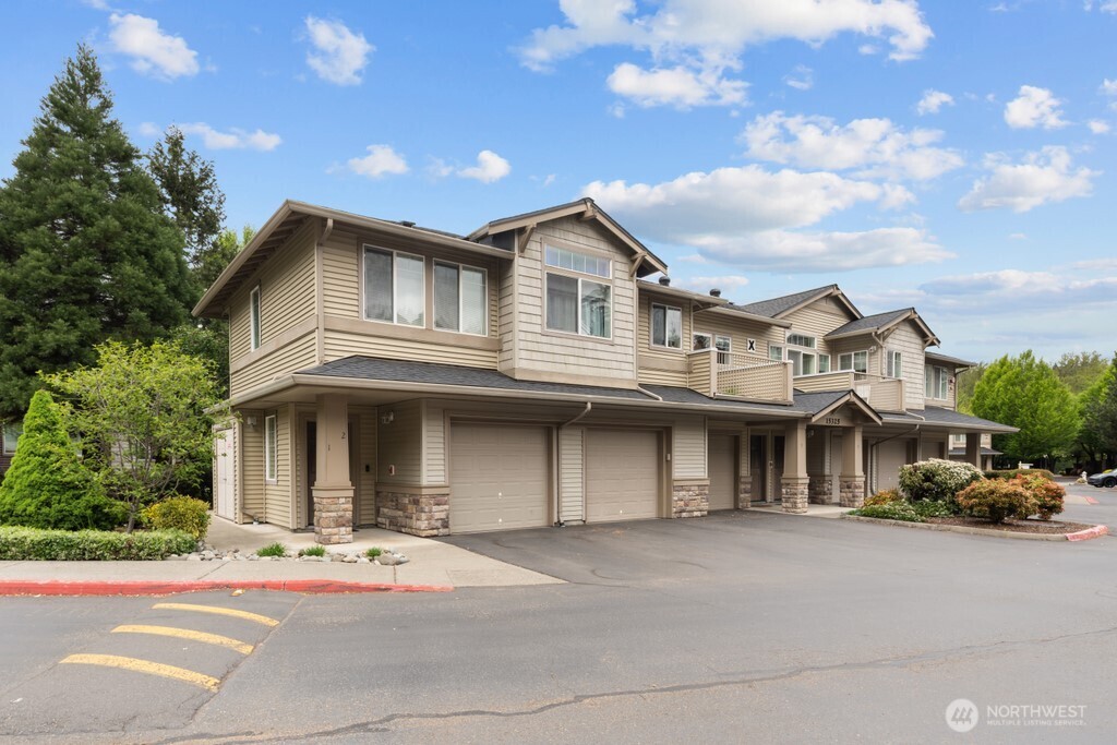 15325 Southeast 155th Place, Unit X1 Renton, WA 98058 - Photo 16 of 21 a front view of a house with a garden and trees