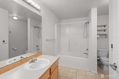 a bathroom with a tub shower sink and mirror
