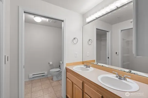 a bathroom with a granite countertop sink toilet and a mirror