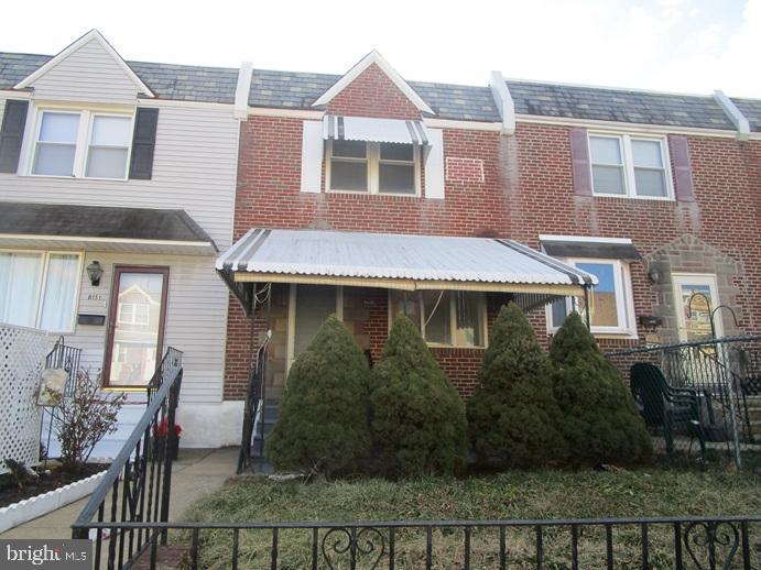 a front view of a house with yard and glass windows