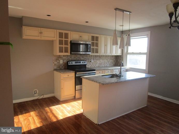 8149 Leon Street Philadelphia, PA 19136 - Photo 9 of 19 a kitchen with stainless steel appliances granite countertop a sink stove and microwave