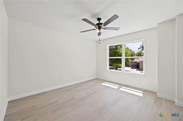 a view of a big room with wooden floor closet and windows
