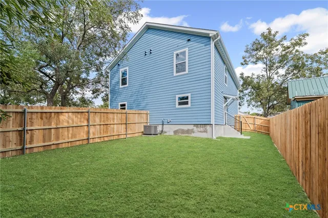 a view of a backyard with wooden fence