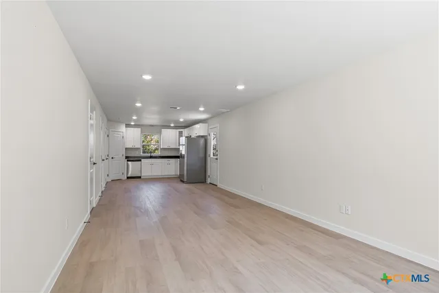 a view of a kitchen with a sink and a refrigerator