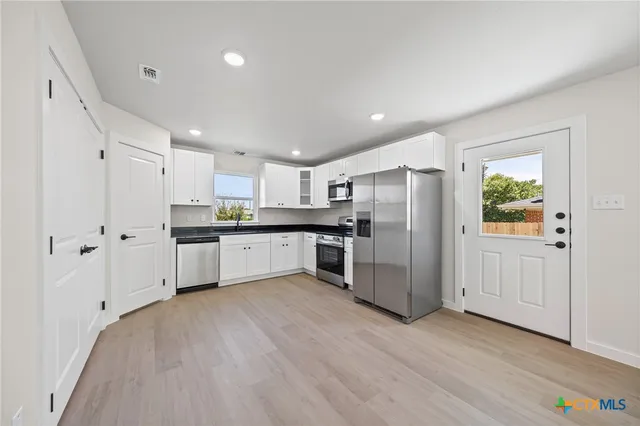 a kitchen with a refrigerator and a sink