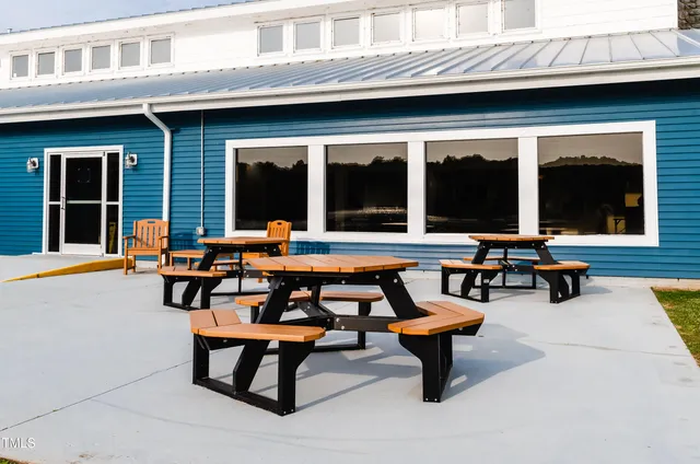 a backyard of a house with outdoor seating and barbeque oven