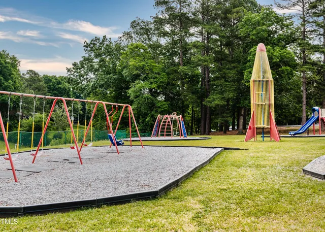 a view of a garden with flowers and wooden fence