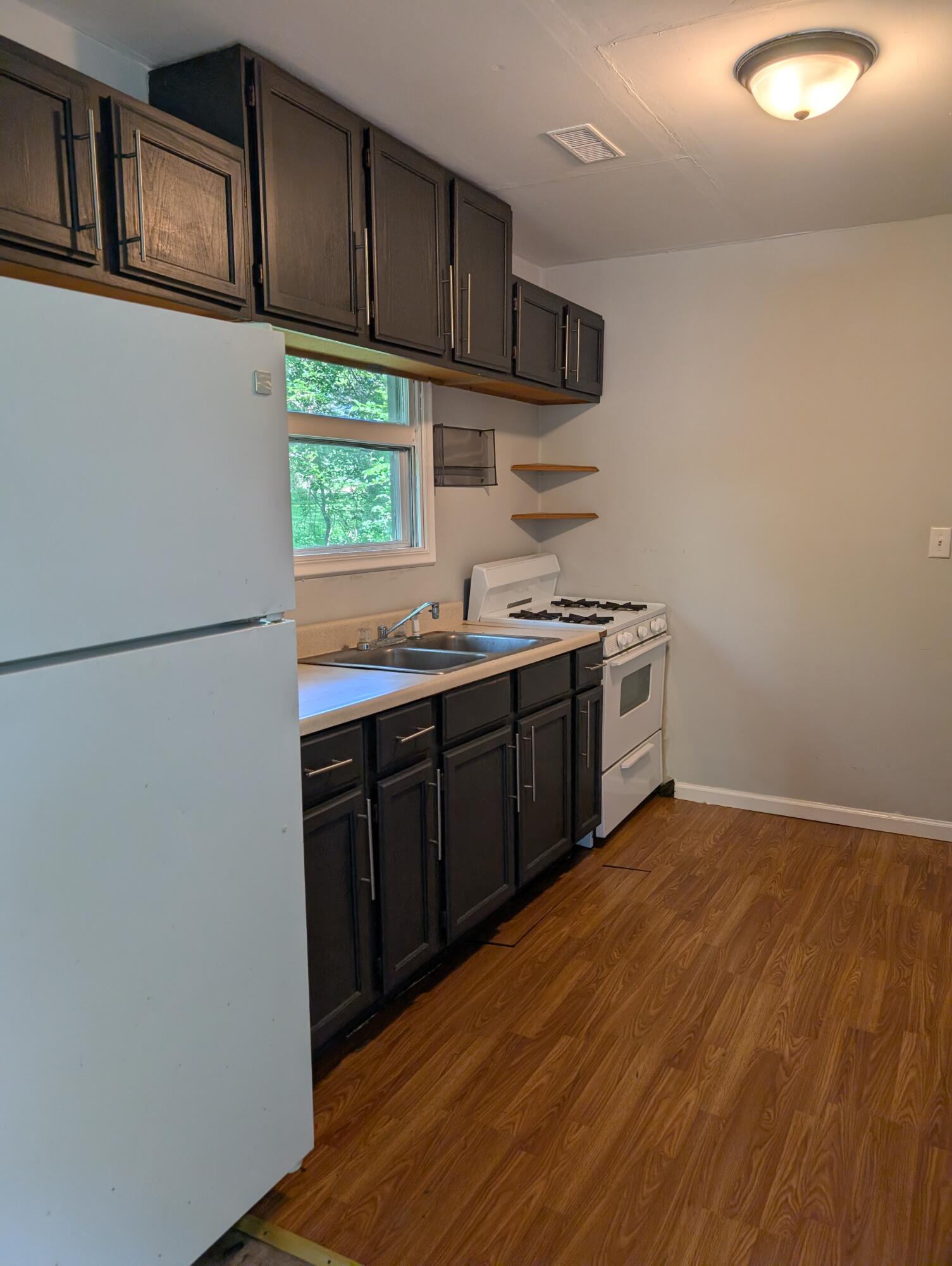 1910 South Calhoun Street Griffith, IN 46319 - Photo 10 of 19 a kitchen with stainless steel appliances a sink cabinets and a wooden floor