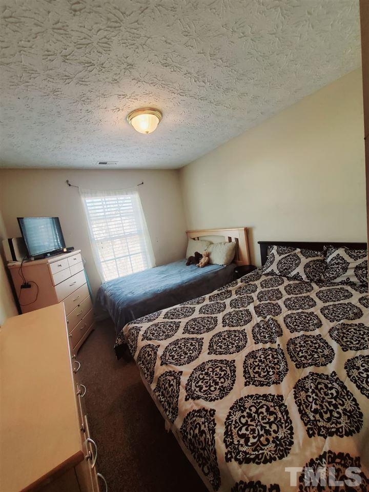 4232 Tensity Drive Raleigh, NC 27604 - Photo 11 of 13 a bed sitting in a bedroom next to a window