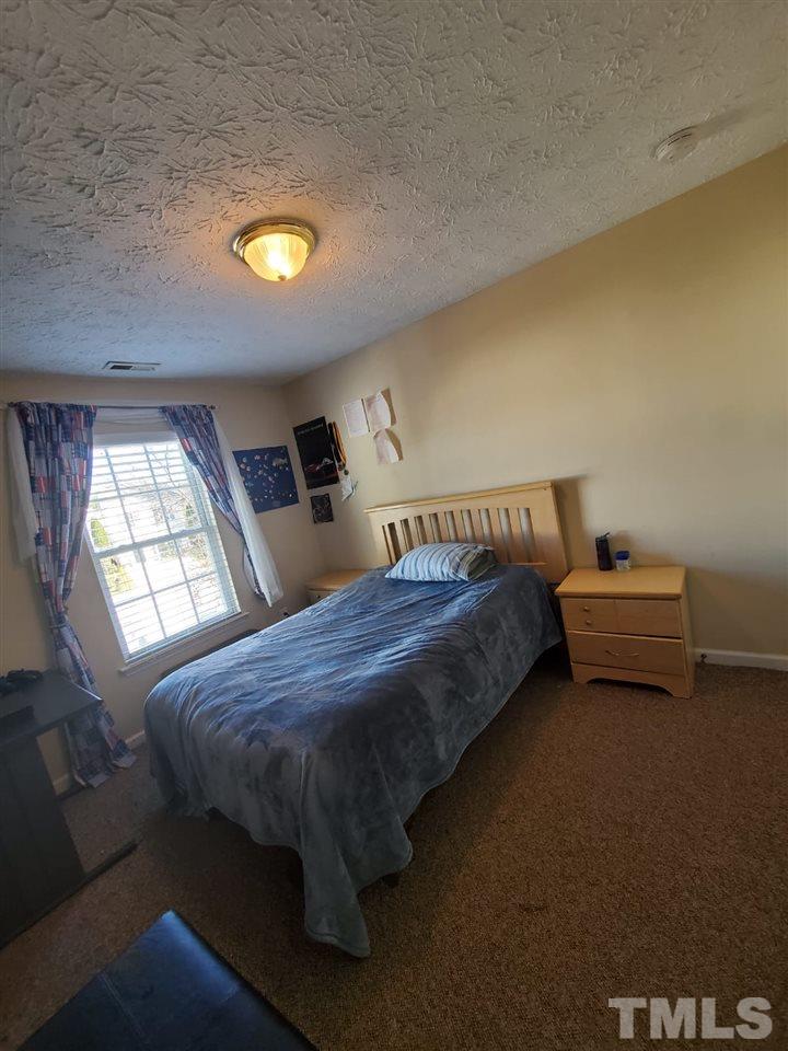 4232 Tensity Drive Raleigh, NC 27604 - Photo 12 of 13 a bed sitting in a bedroom next to a window