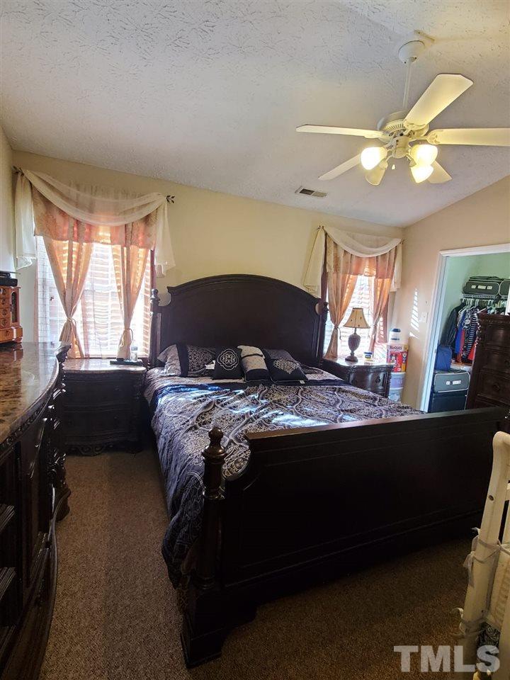 4232 Tensity Drive Raleigh, NC 27604 - Photo 8 of 13 a bedroom with a bed and a chandelier