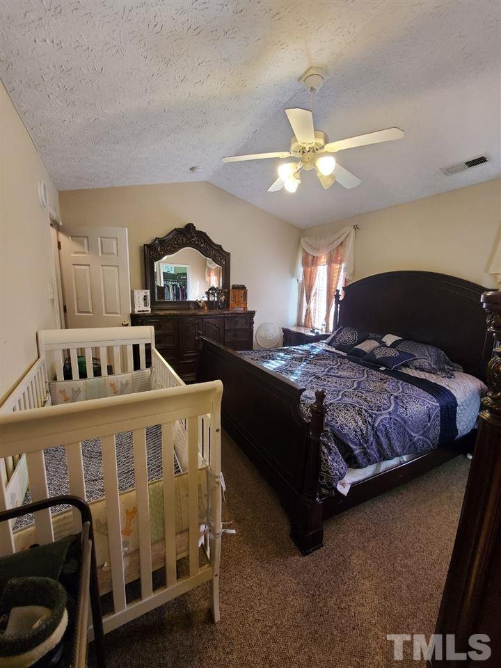 4232 Tensity Drive Raleigh, NC 27604 - Photo 9 of 13 a bedroom with a bed and a ceiling fan