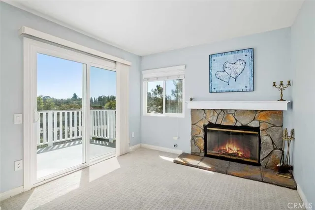 a living room with a fireplace and a floor to ceiling window