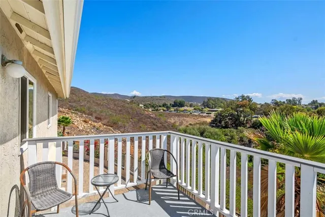 a view of a balcony with wooden floor and fence