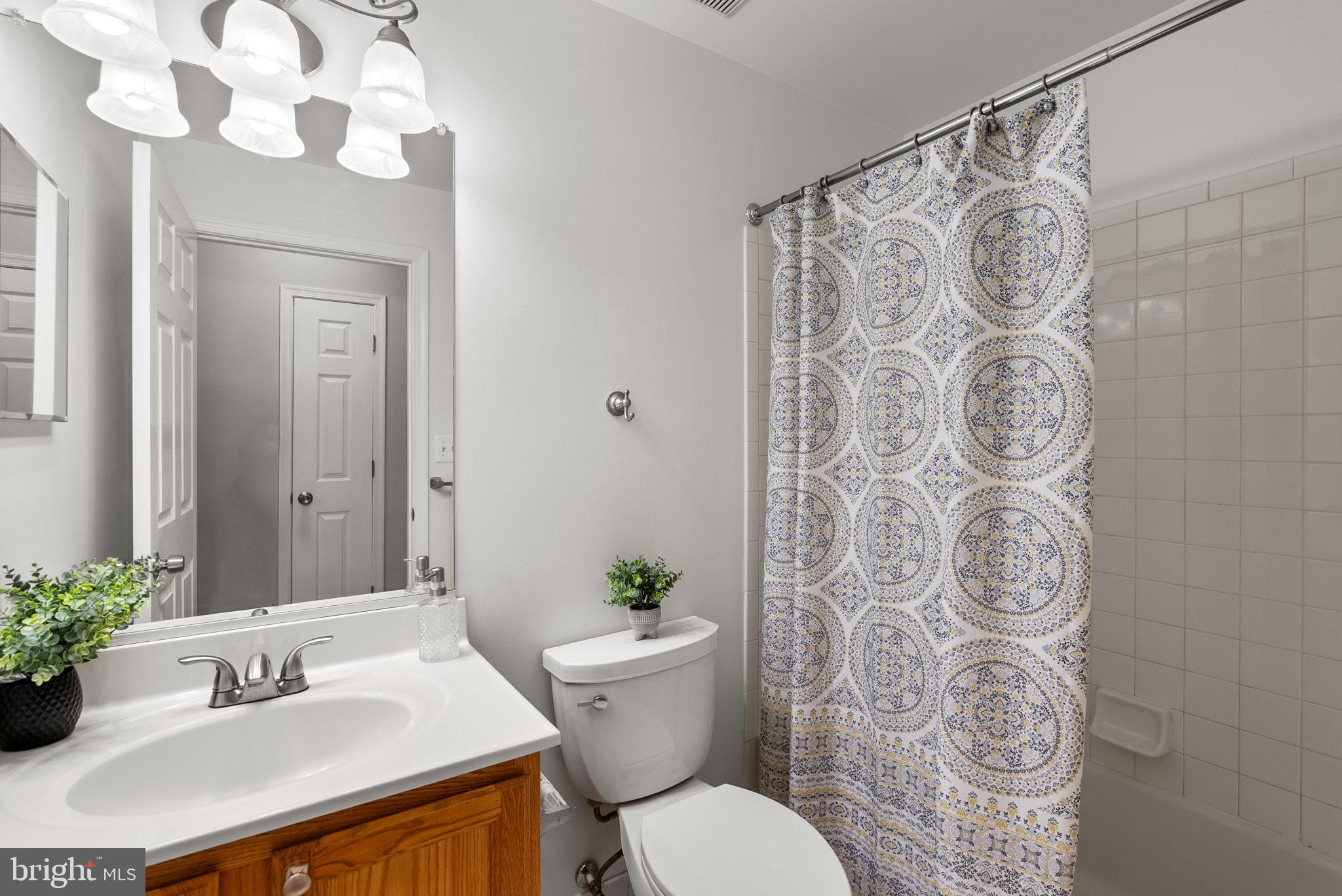 12708 Found Stone Road, Unit 3304 Germantown, MD 20876 - Photo 21 of 40 a bathroom with a sink a toilet and shower curtain