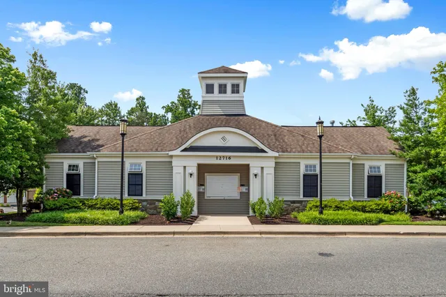 a view of a white house with a yard and potted plants