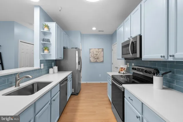 a kitchen with stainless steel appliances a stove a sink island and a refrigerator