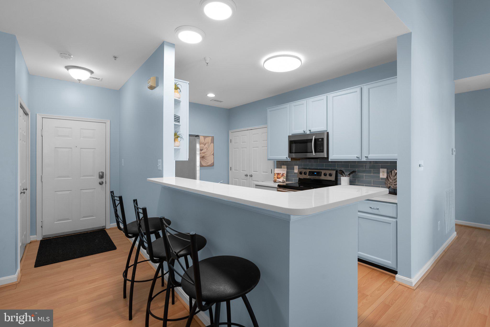 12708 Found Stone Road, Unit 3304 Germantown, MD 20876 - Photo 9 of 40 a kitchen with stainless steel appliances a stove a sink island and a refrigerator