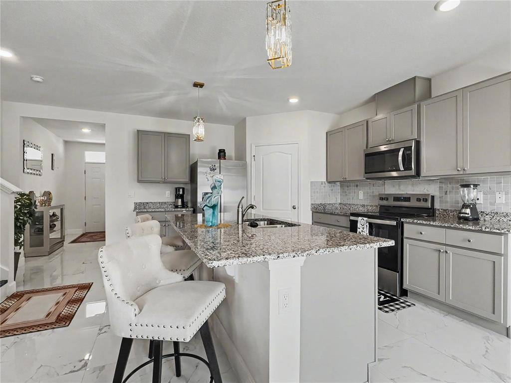 2085 Doe Run Drive Davenport, FL 33837 - Photo 15 of 44 a kitchen with sink a microwave and cabinets