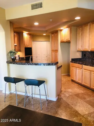a kitchen with stainless steel appliances granite countertop a sink and a white cabinets