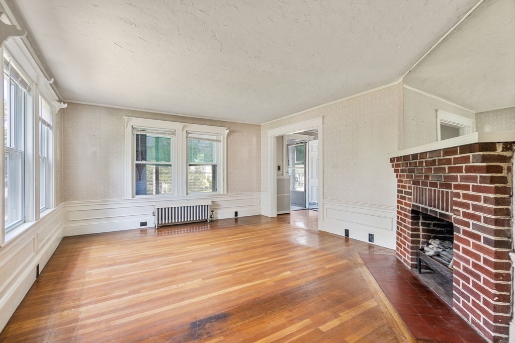 39 Reedsdale Road Milton, MA 02186 - Photo 3 of 25 a view of an empty room with a window and wooden floor
