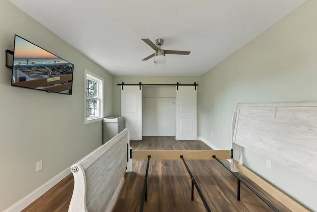 a view of a hallway with wooden floor and cabinet