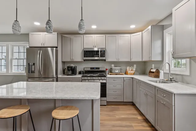a kitchen with kitchen island a sink stove and refrigerator