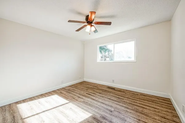 a view of a room with wooden floor and a ceiling fan