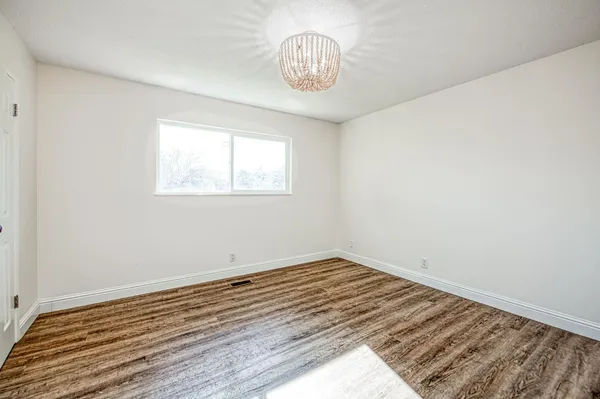 a view of a room with wooden floor and a ceiling fan