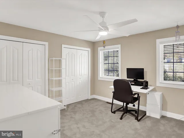 a view of a workspace with furniture and a window