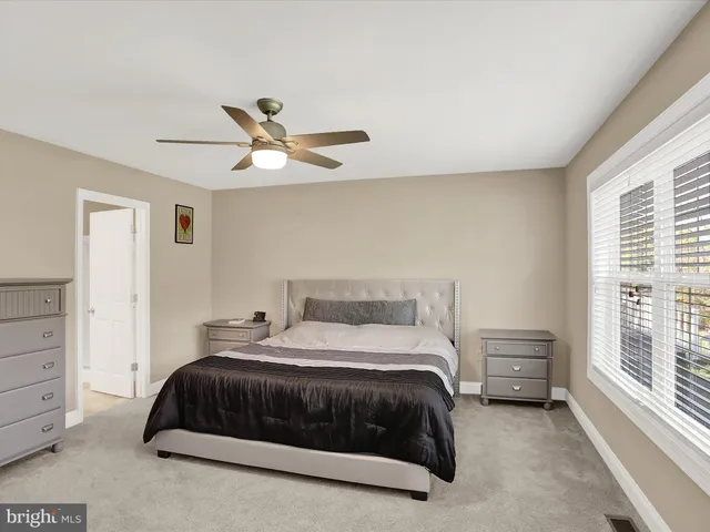 a bedroom with a bed and a ceiling fan