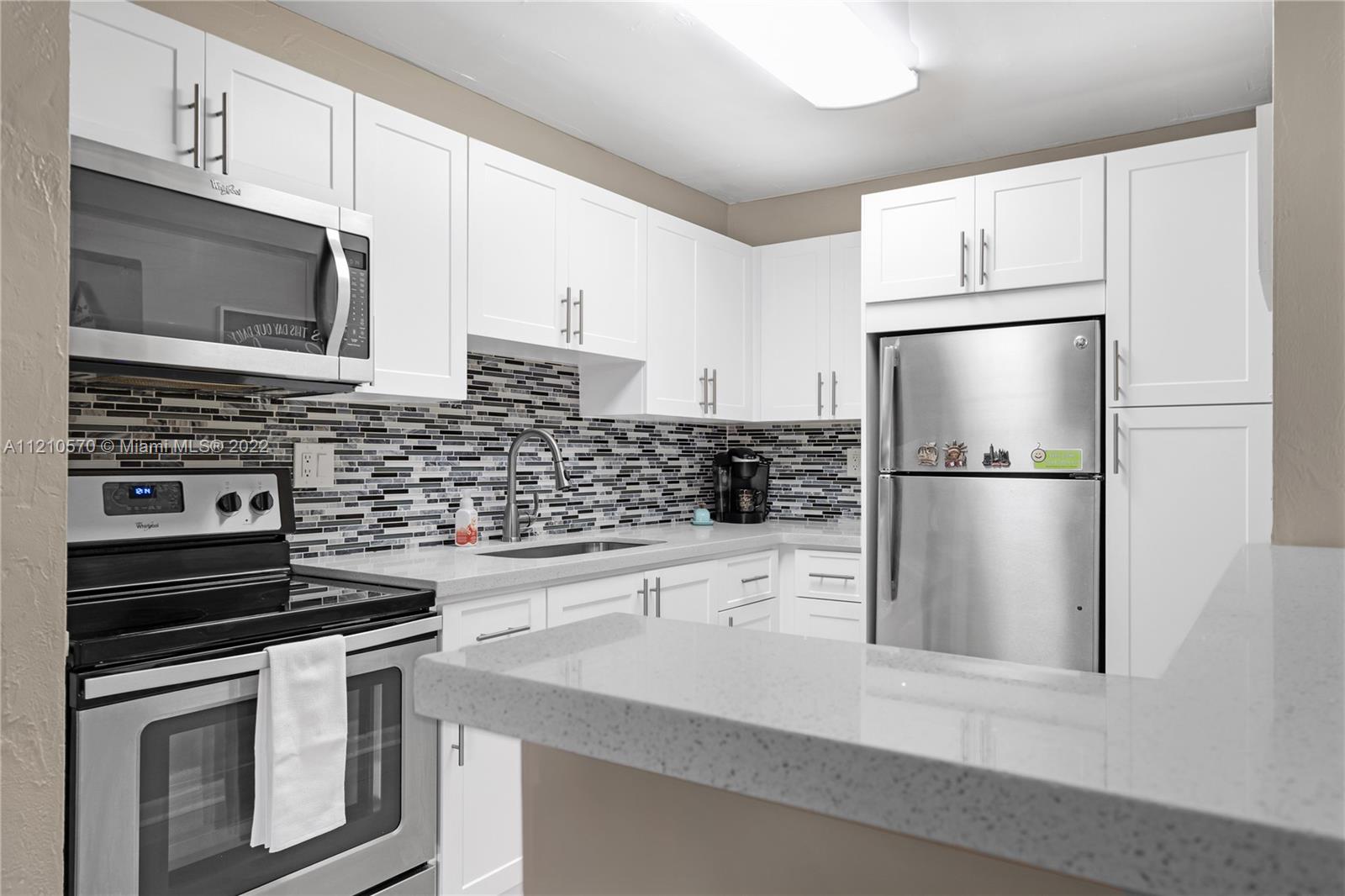 9459 Southwest 76th Street, Unit R7 Miami, FL 33173 - Photo 14 of 24 a kitchen with a refrigerator stove and microwave