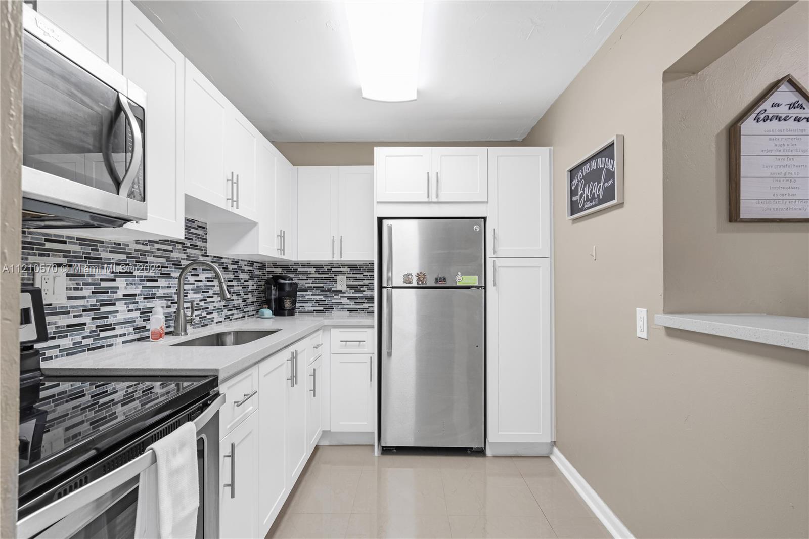 9459 Southwest 76th Street, Unit R7 Miami, FL 33173 - Photo 15 of 24 a kitchen with a sink stove and refrigerator