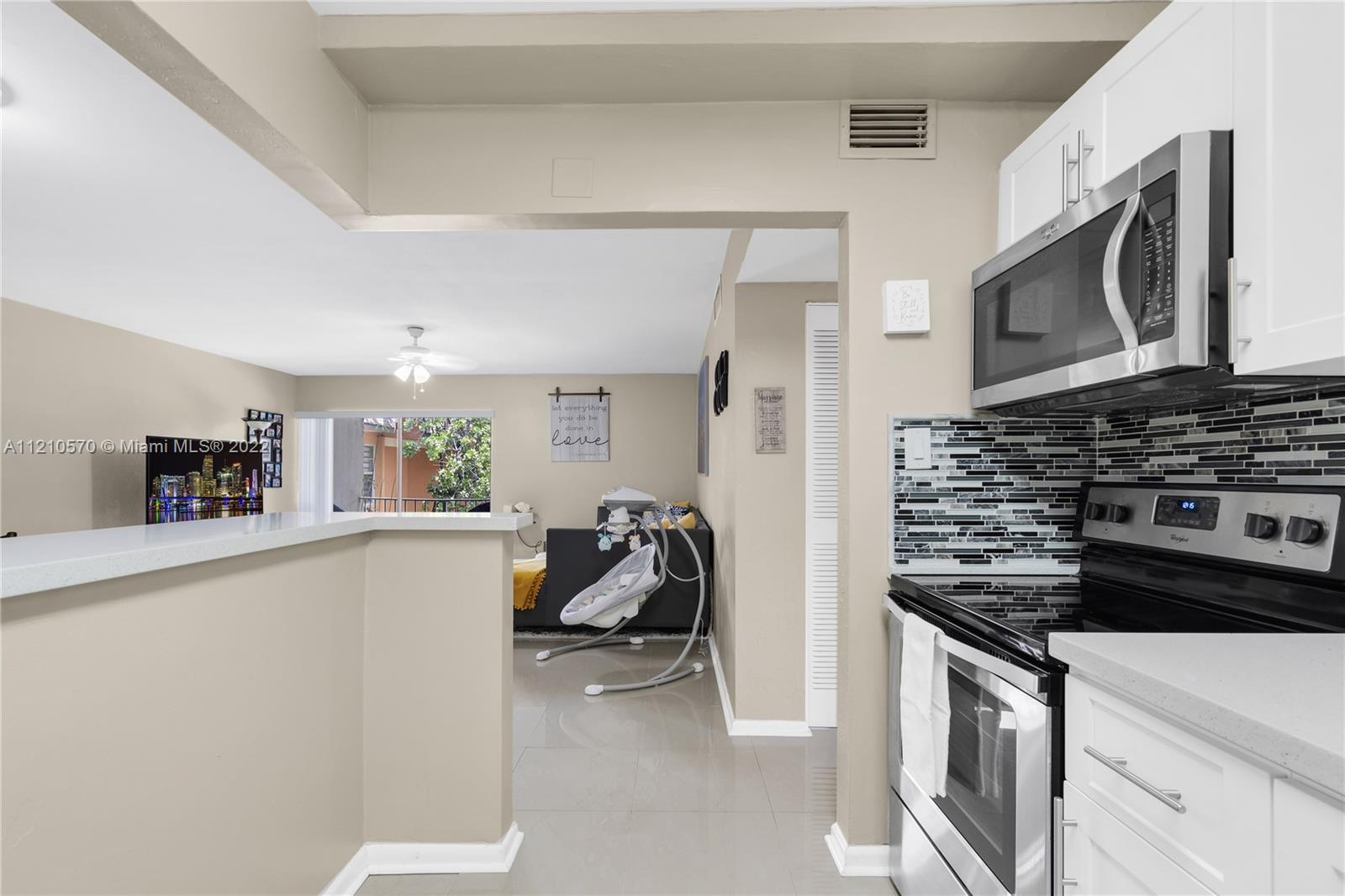 9459 Southwest 76th Street, Unit R7 Miami, FL 33173 - Photo 16 of 24 a kitchen with stainless steel appliances a stove a microwave and a refrigerator