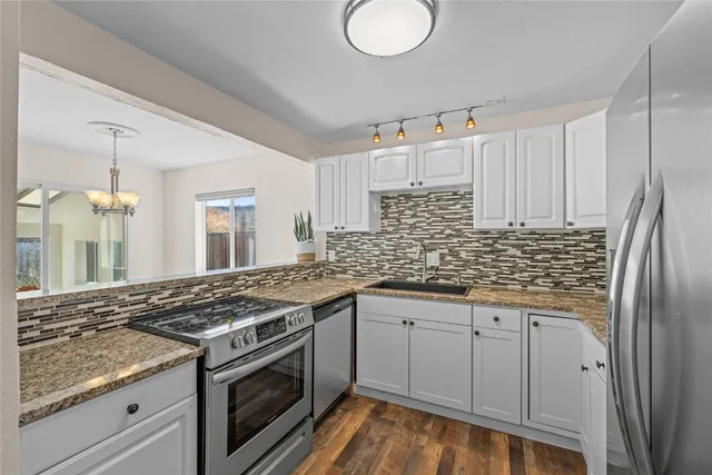 a kitchen with stainless steel appliances granite countertop a sink stove and refrigerator