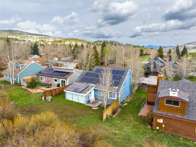 an aerial view of a house with swimming pool and large trees
