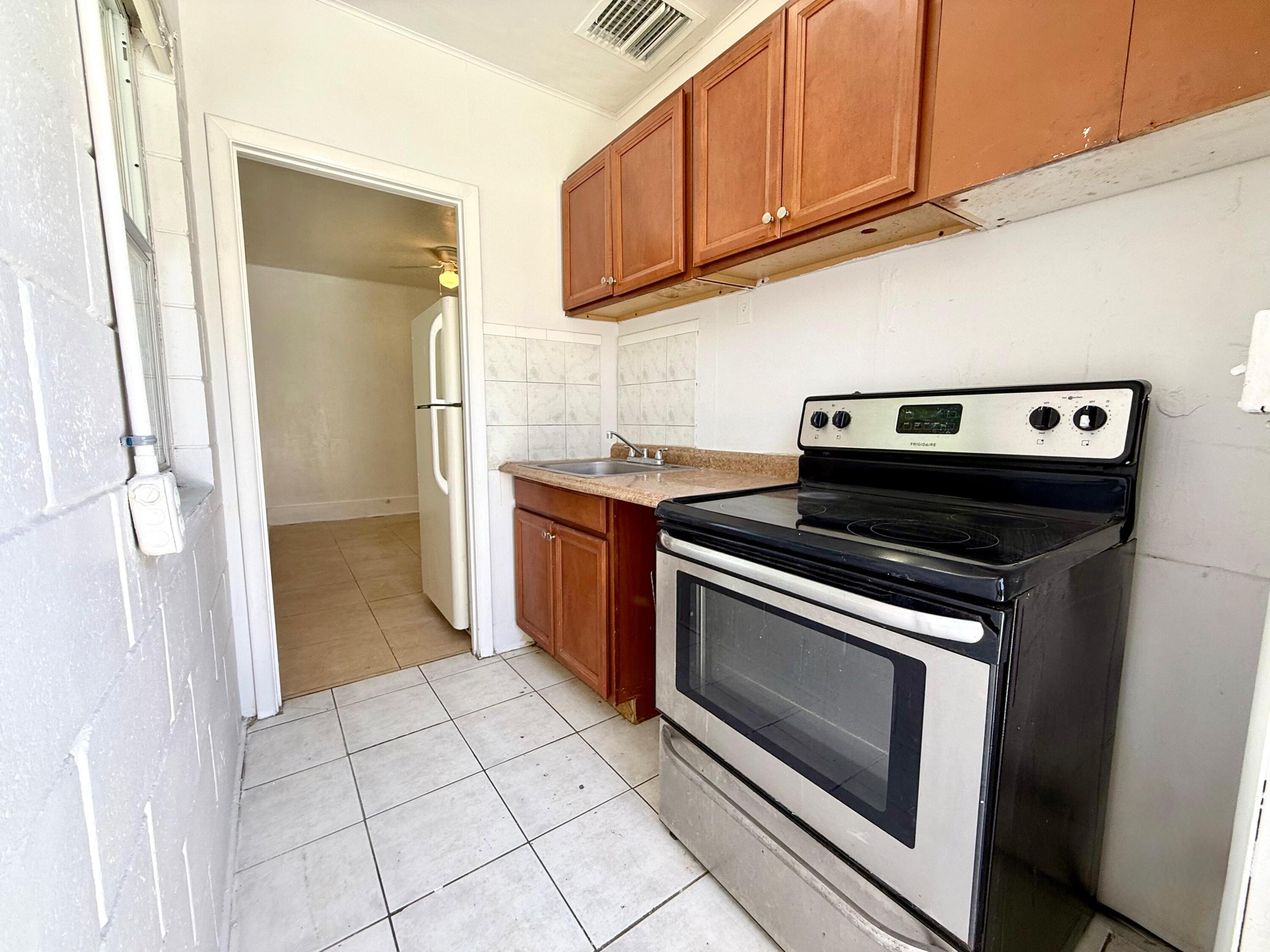 926 33rd Street, Unit BACK West Palm Beach, FL 33407 - Photo 1 of 7 a kitchen with a stove top oven and cabinets