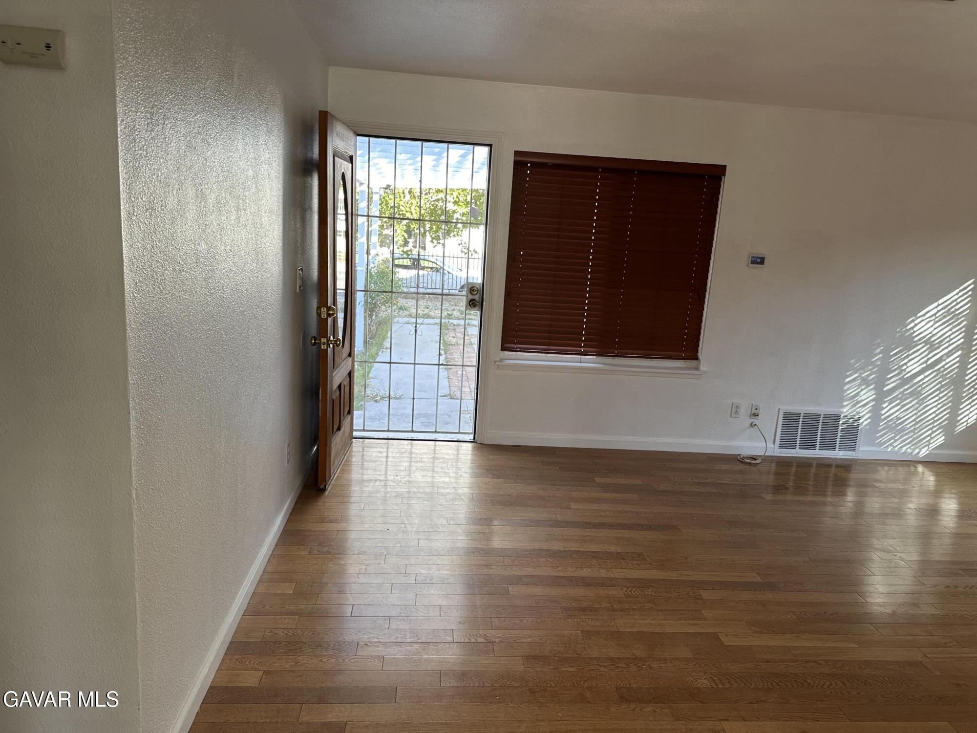 42901 Alep Street Lancaster, CA 93536 - Photo 10 of 11 a view of an empty room with wooden floor and a window