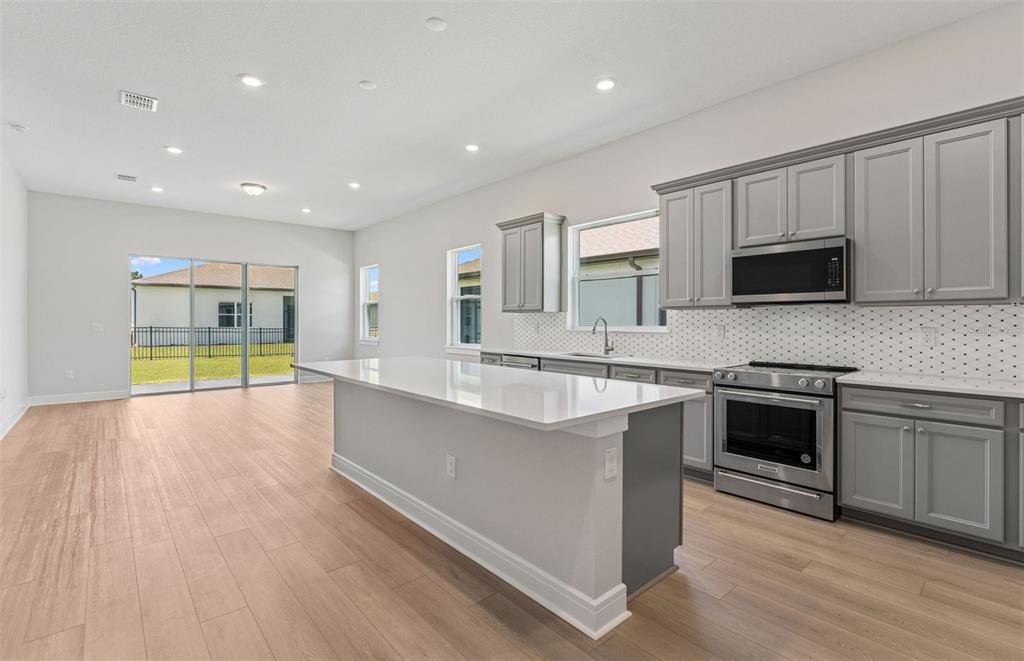 5230 Southwest 88th Circle Ocala, FL 34481 - Photo 4 of 35 a large kitchen with stainless steel appliances granite countertop a stove and a sink
