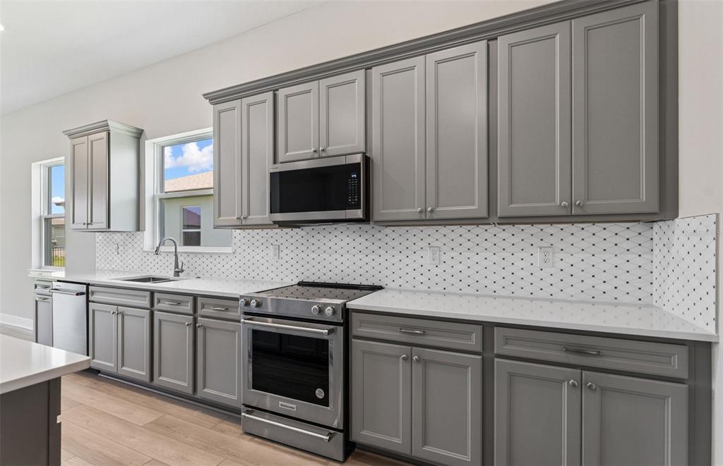 5230 Southwest 88th Circle Ocala, FL 34481 - Photo 5 of 35 a kitchen with stainless steel appliances granite countertop white cabinets a sink and dishwasher
