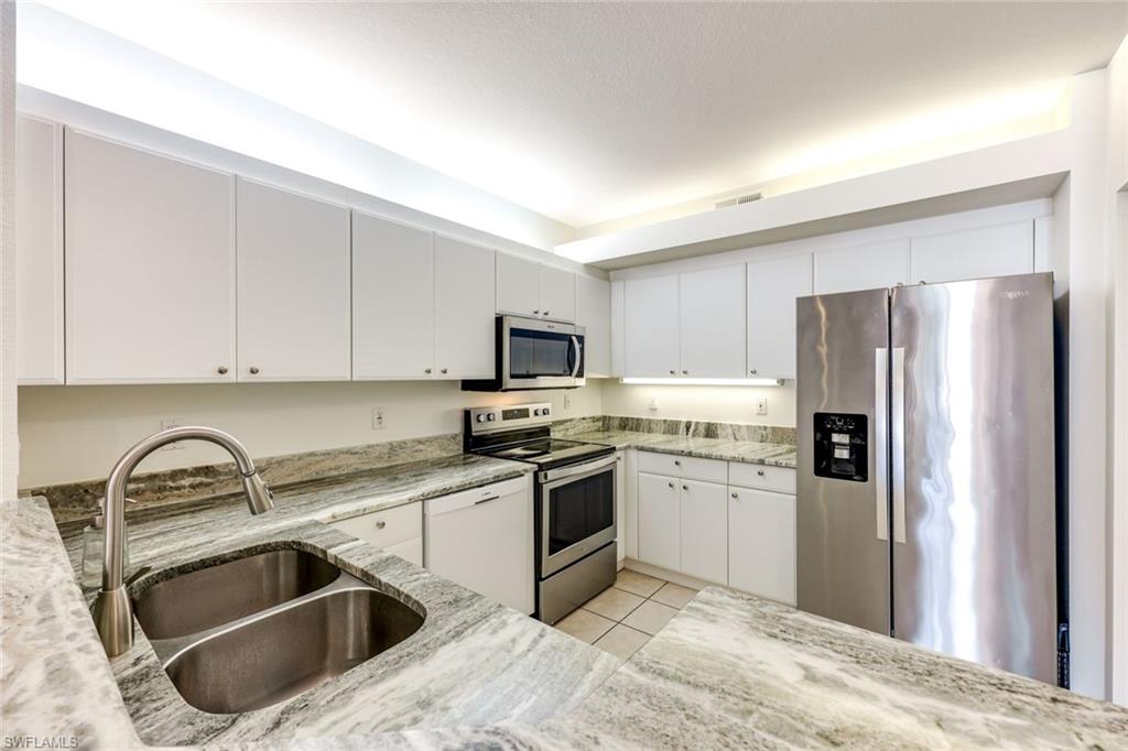 10921 Santa Margherita Road, Unit 103 Estero, FL 34135 - Photo 11 of 38 a kitchen with a sink stove and refrigerator
