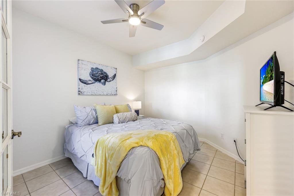 10921 Santa Margherita Road, Unit 103 Estero, FL 34135 - Photo 16 of 38 a bedroom with a bed and a flat screen tv