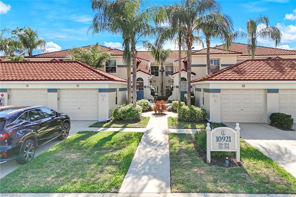 10921 Santa Margherita Road, Unit 103 Estero, FL 34135 - Photo 29 of 38 a front view of a house with garden