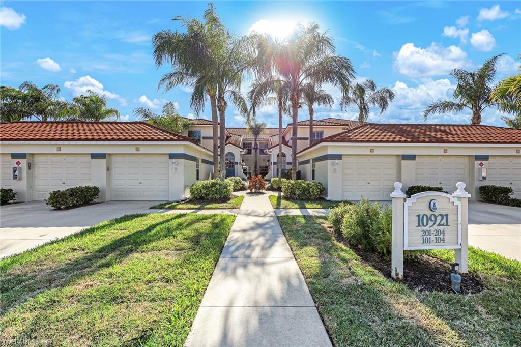 10921 Santa Margherita Road, Unit 103 Estero, FL 34135 - Photo 33 of 38 a front view of a house with a yard and garage