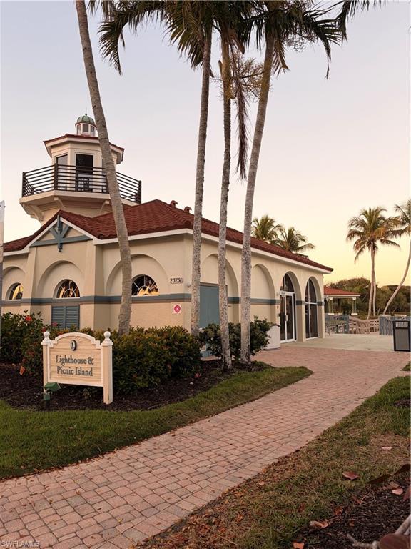 10921 Santa Margherita Road, Unit 103 Estero, FL 34135 - Photo 34 of 38 a front view of a house with a garden and yard