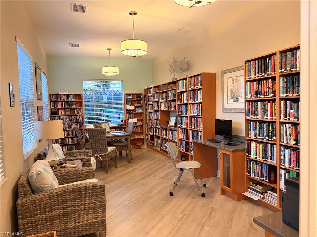 10921 Santa Margherita Road, Unit 103 Estero, FL 34135 - Photo 36 of 38 a living room with furniture and a book shelf