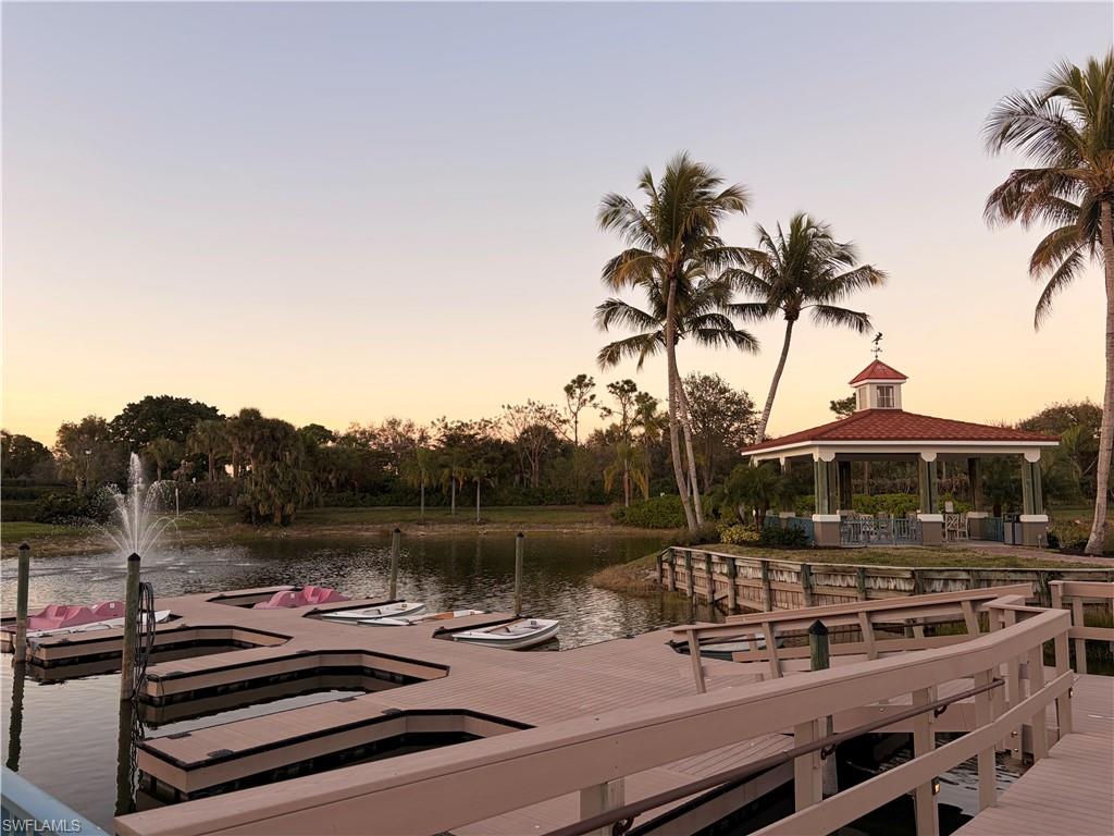 10921 Santa Margherita Road, Unit 103 Estero, FL 34135 - Photo 37 of 38 a view of a lake with couches and wooden fence